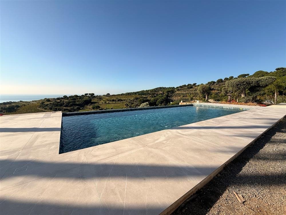 Terraza y piscina infinita terminada con vistas al Maresme